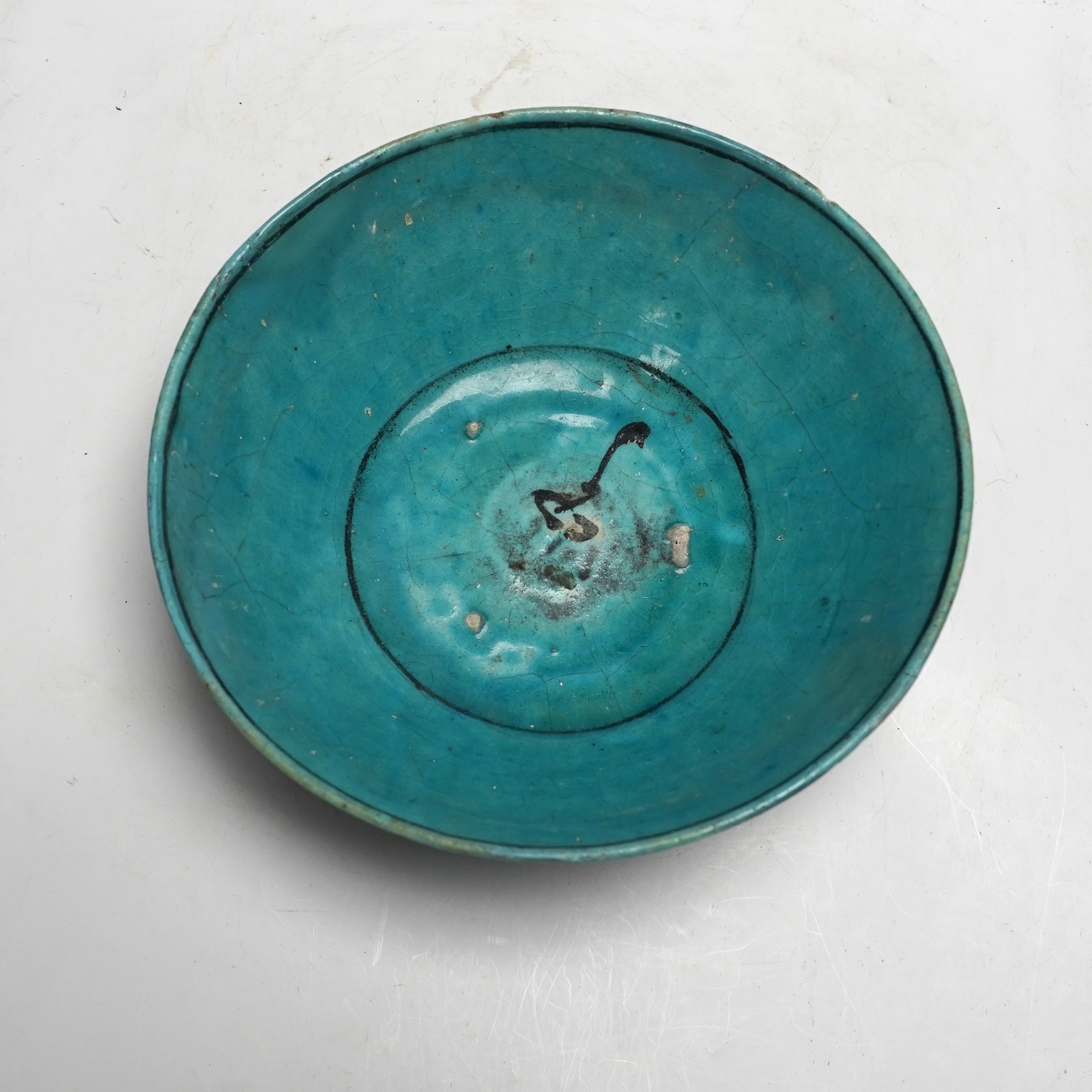 A Kashan turquoise glazed fritware bowl, Persia, 13th/14th century, 25cm diameter